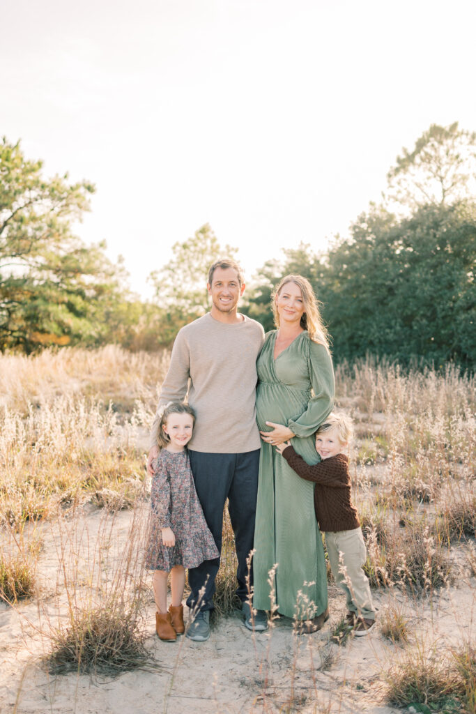 family of 4 posing for fall family photos in virginia beach 