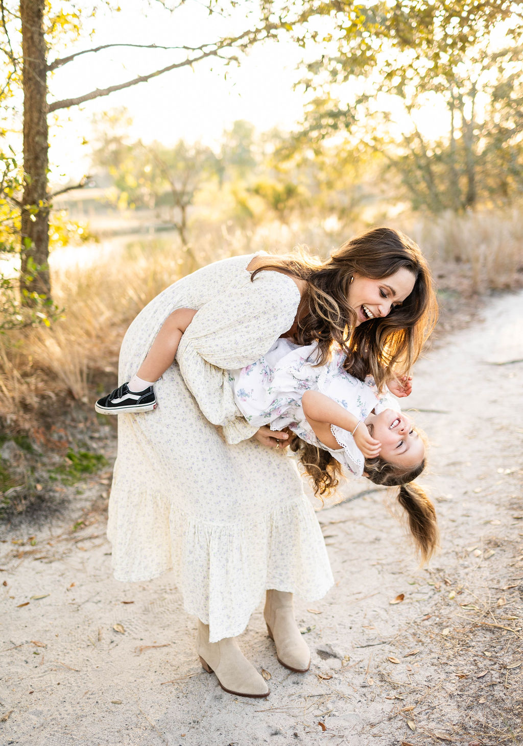 mother and daughter laughing and dancing during family photos in Virginia Beach by Chelsey Kraus Photography