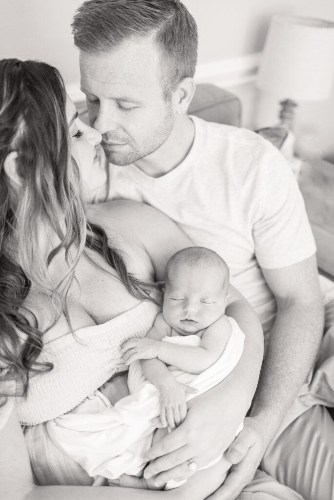 new mom and dad snuggling baby newborn girl during newborn photos at their home in virginia beach