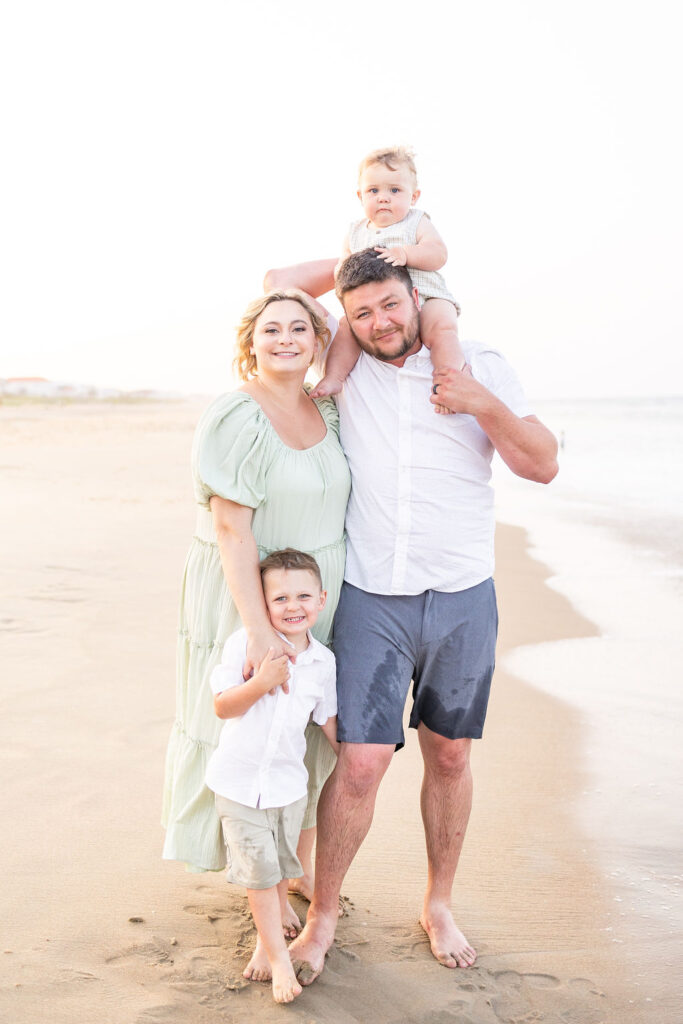 Sandbridge Beach featuring a family of four posing on the beach
