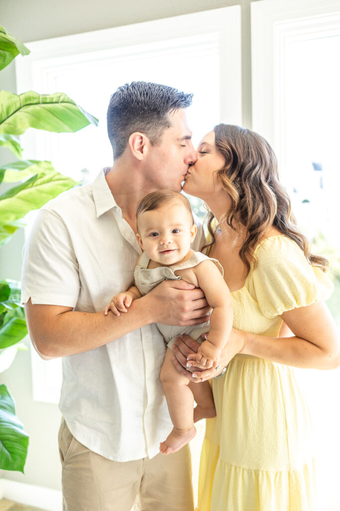 family photos in home with mom and dad kissing 