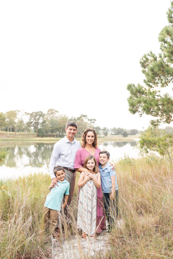 Pleasure House Natural Area featuring a family of five posing near the water