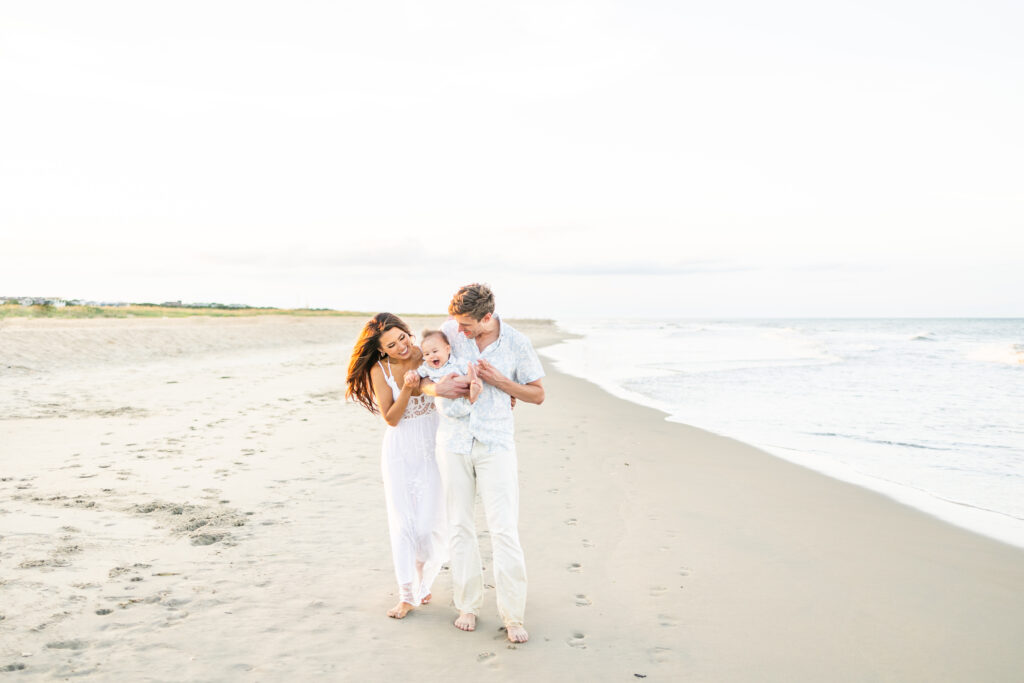 Family of three posing in the dunes during a Virginia Beach photoshoot