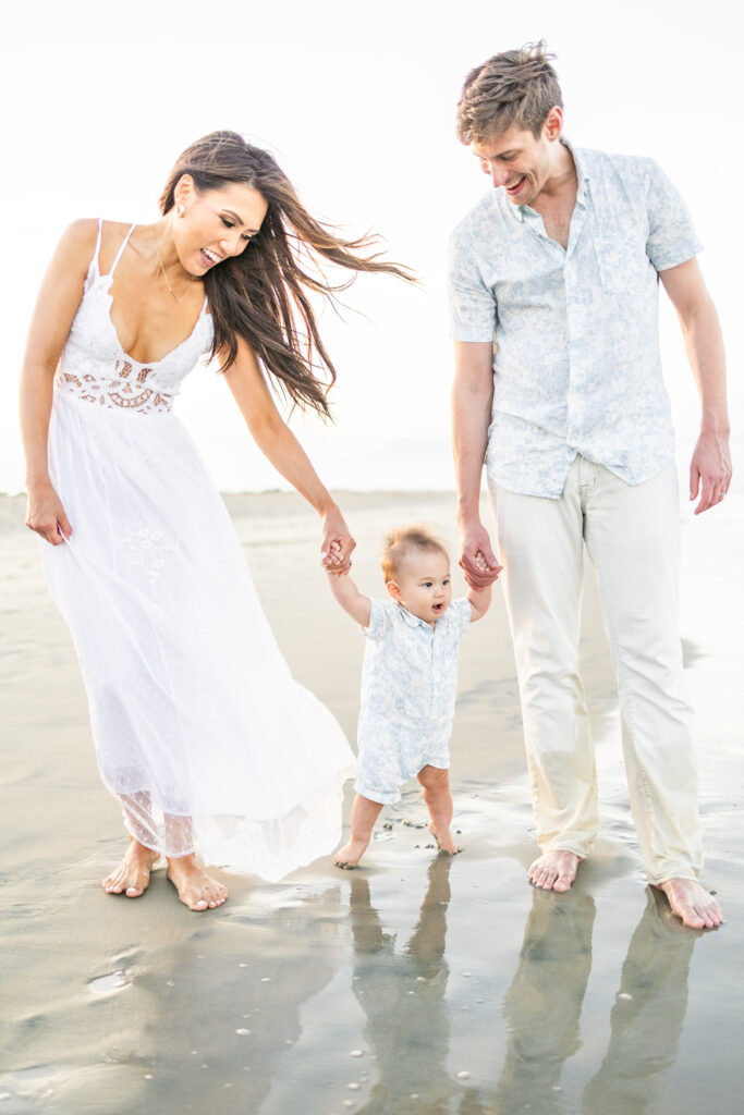 Family of three posing in the dunes during a Virginia Beach photoshoot