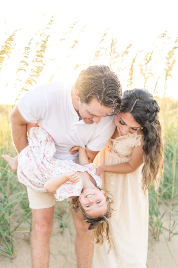 family of 3 having fun during their virginia beach north end family photos