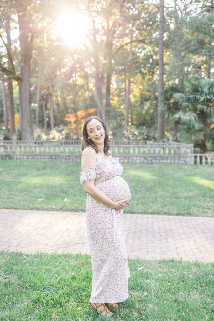 pregnant mother smiling during maternity photos at the norfolk botanical gardens in virginia, usa