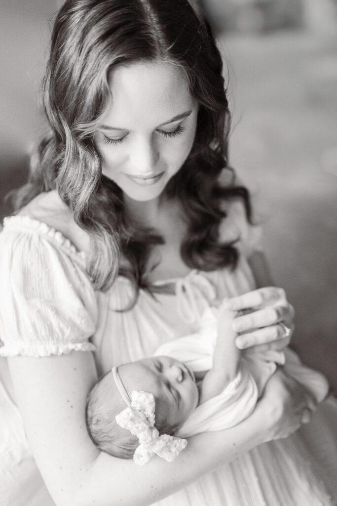 mom holding newborn baby girl during newborn photos at home