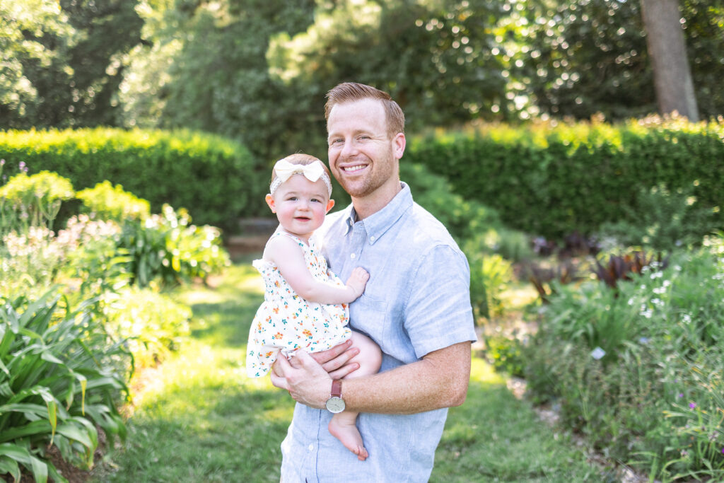 dad holding 1 year old baby daughter during her first birthday photoshoot
