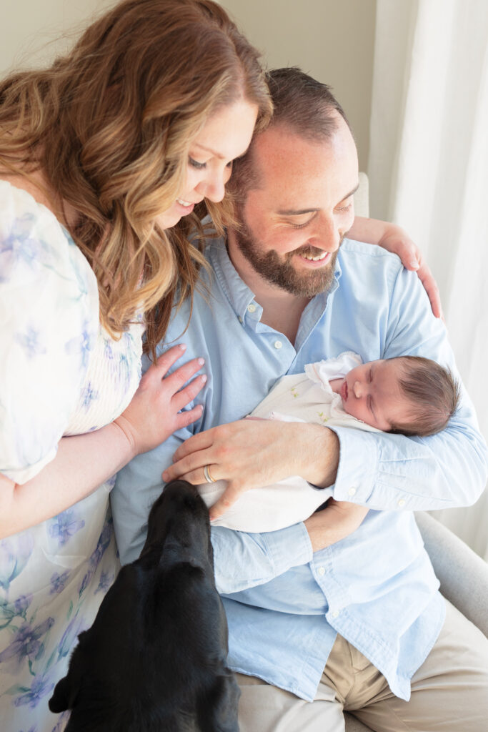 in-home newborn photos featuring a beautiful set of first time parents and dog with baby girl