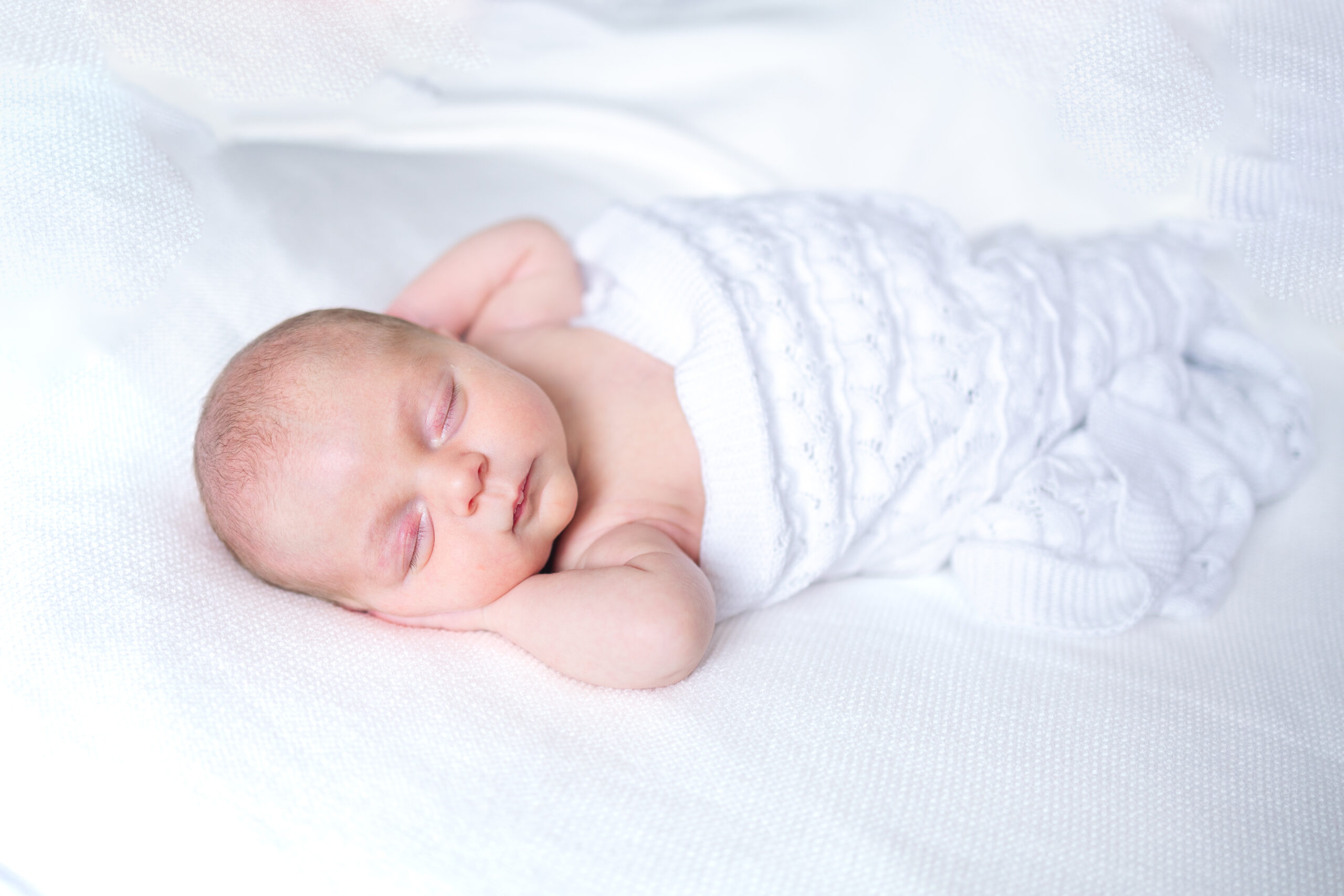 Sweet baby girl newborn photos featuring a baby sleeping in a white blanket